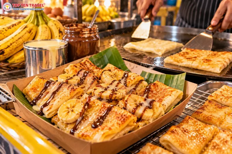 Bánh Roti chuối giòn thơm kết hợp cùng sữa đặc và sốt chocolate là món ăn vặt hấp dẫn khi khám phá chợ đêm Chillva Market