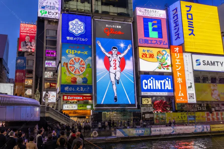 Giữa không gian rực rỡ ánh đèn neon, biển hiệu Glico trở thành biểu tượng đặc trưng mà bất kỳ du khách nào cũng muốn lưu lại