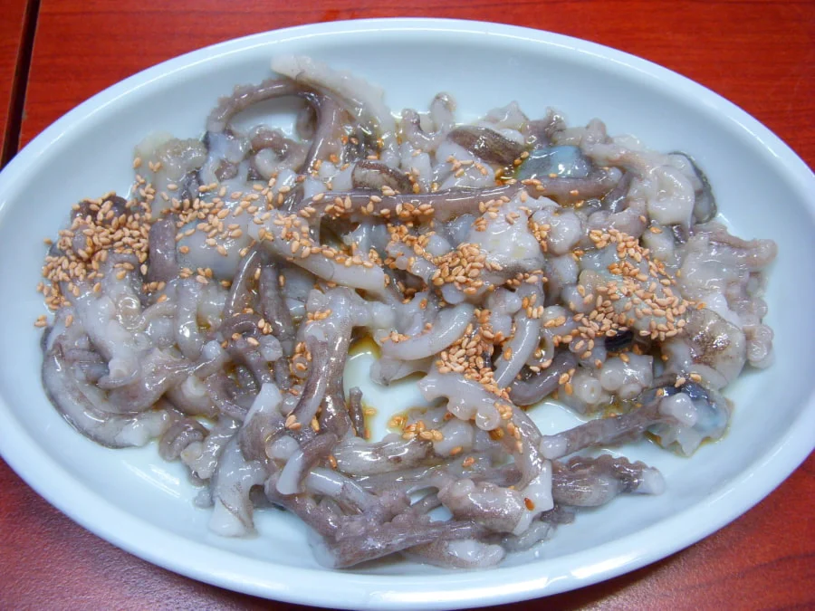 Những chú bạch tuộc nhỏ, còn tươi rói, được cắt thành những miếng vừa ăn và bày ra đĩa khi các xúc tu vẫn còn ngoe nguẩy