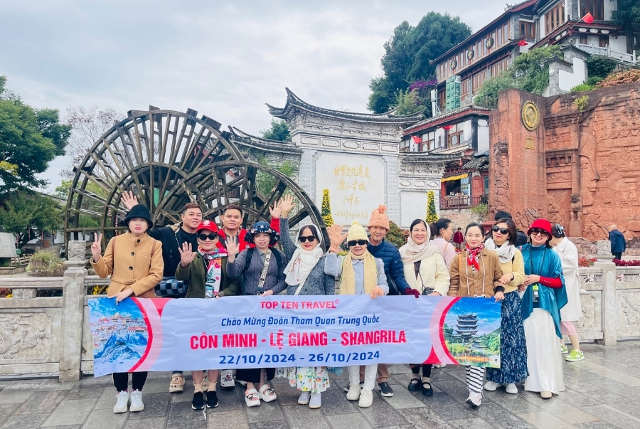 Đoàn khách nhà Top Ten Travel check-in bên bánh xe nước biểu tượng cổ kính của Lệ Giang