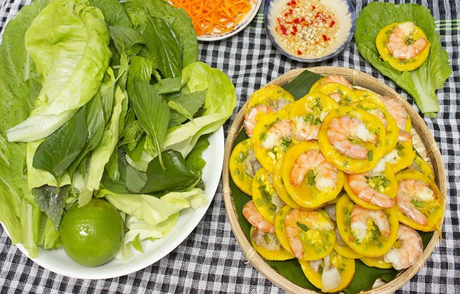 Bánh khọt Cà Mau thường ăn kèm với các loại rau sống, đồ chua và nước chấm pha chua ngọt