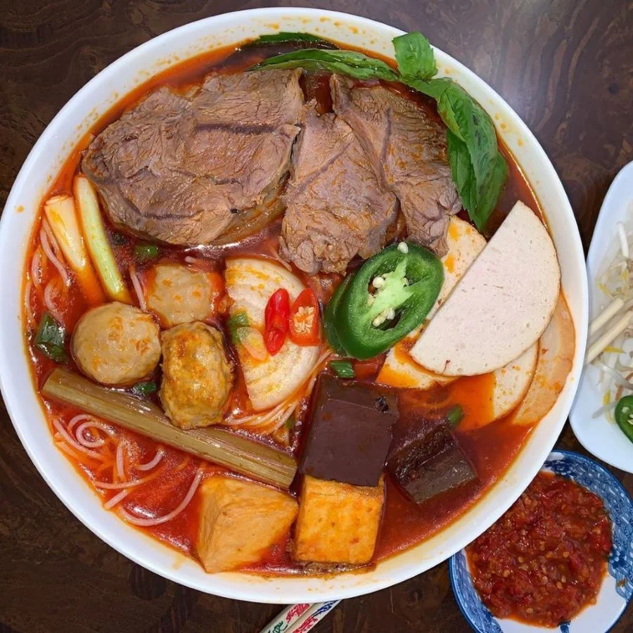 Bún bò Đà Nẵng sử dụng bún sợi nhỏ, nước dùng đậm mùi sa tế, ăn cùng thịt tái và bắp bò