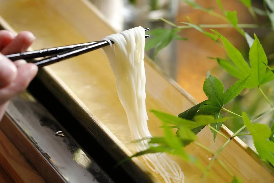 Những sợi mì sẽ được thả trôi theo dòng nước mát trong ống tre, thực khách dùng đũa để vớt mì và thưởng thức