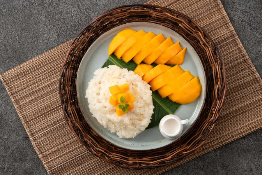 Hạt xôi sau khi nấu chín dẻo quánh và trắng mịn, thưởng thức cùng với những miếng xoài chín thơm phức, mọng nước và ngọt lịm