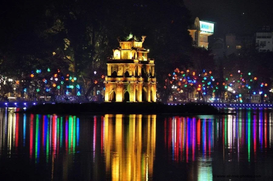 Ánh đèn vàng rực rỡ từ những con đường ven hồ, những tòa nhà cao tầng xung quanh soi bóng xuống mặt hồ phẳng lặng tạo nên một khung cảnh vô cùng thơ mộng